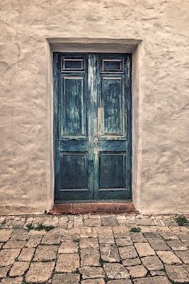 Blauwe deur in witte stenen muur