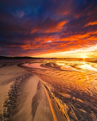 Solnedgang ved sandstrand