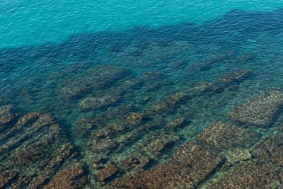 Turquoise zeewater en rotsen