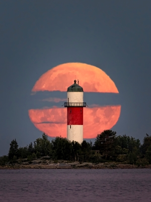 Full moon behind lighthouse