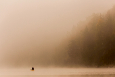 Un hombre en una canoa en un hermoso entorno