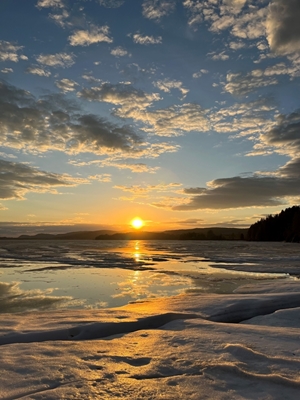Sunset over ice covered lake