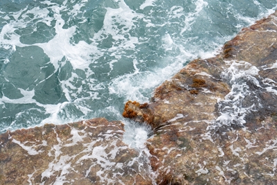 Blått havsvatten, våg och stenar