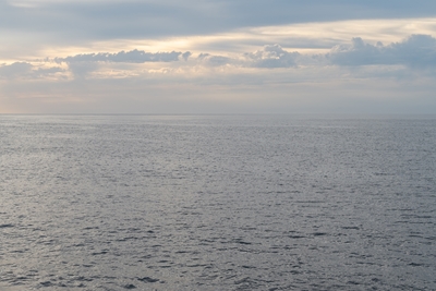 Silvergrått hav och molnig himmel