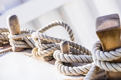 Ropes on wooden cleats on boat