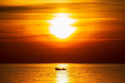 Liten båt ved solnedgang
