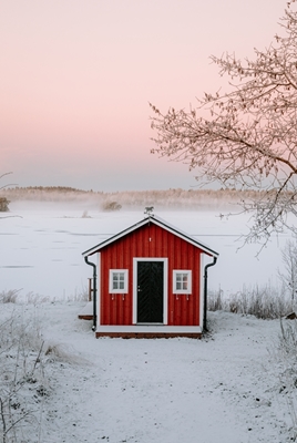 Rødt bådehus i vinterlandskab