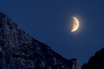 Waxing moon behind mountain