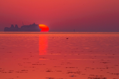 Un bateau cache le coucher de soleil