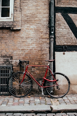 Vélo rouge et mur de pierre