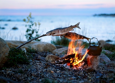 Il pescato viene grigliato sul fuoco.