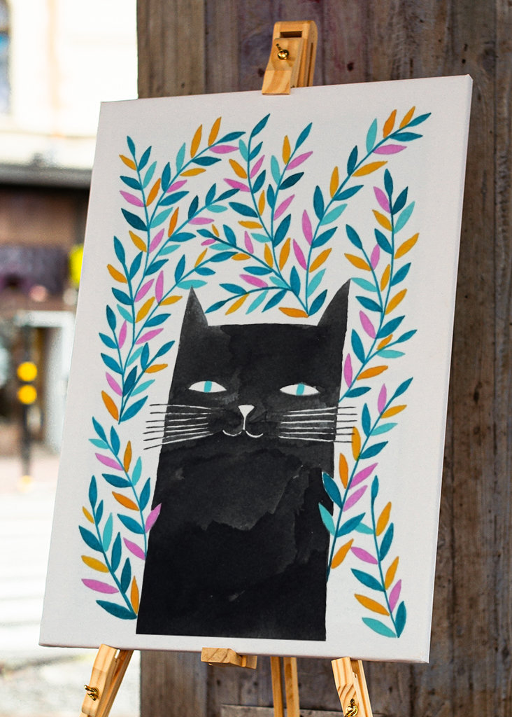 svart katt med blå blader