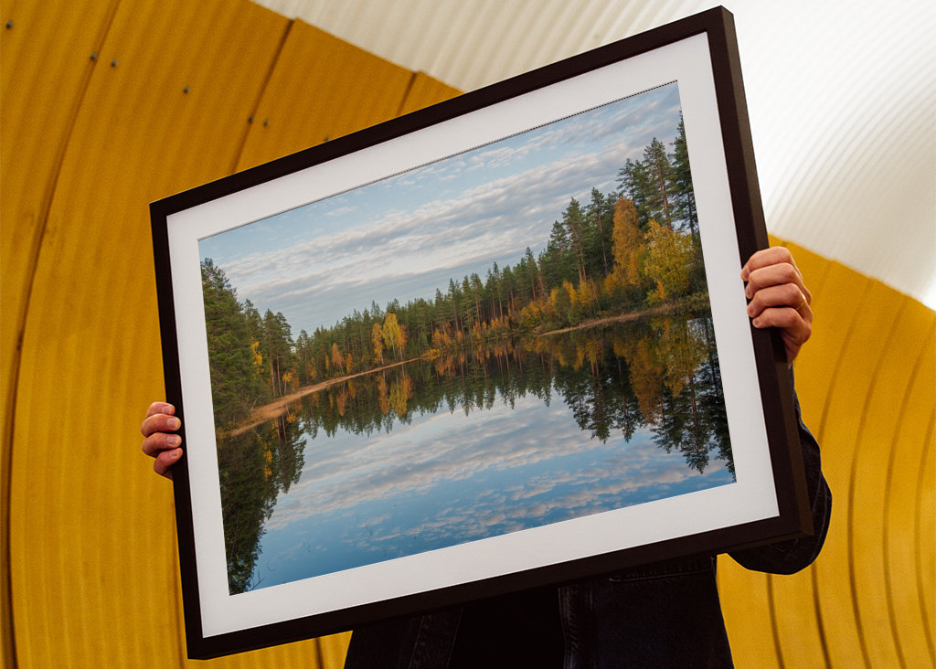 Herbstwald spiegelt sich im Wasser.