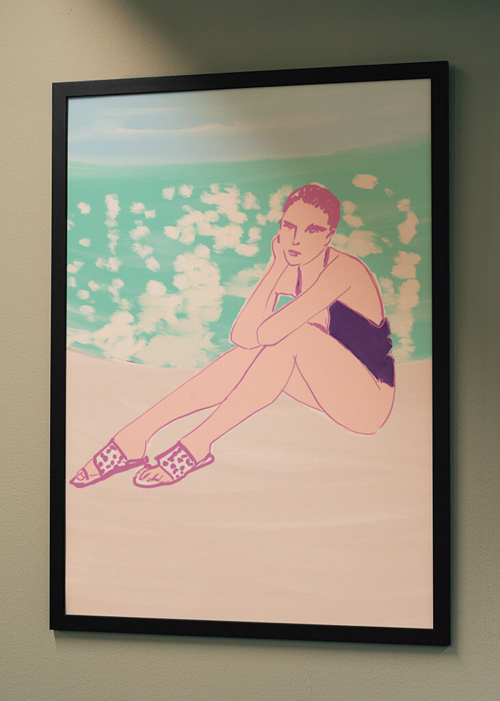 Woman in a Black Swimsuit Seated on a Beach