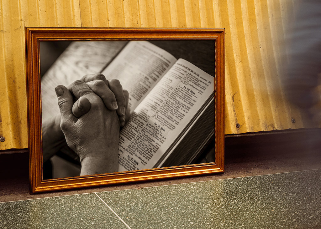 Bedjande händer över en bibel